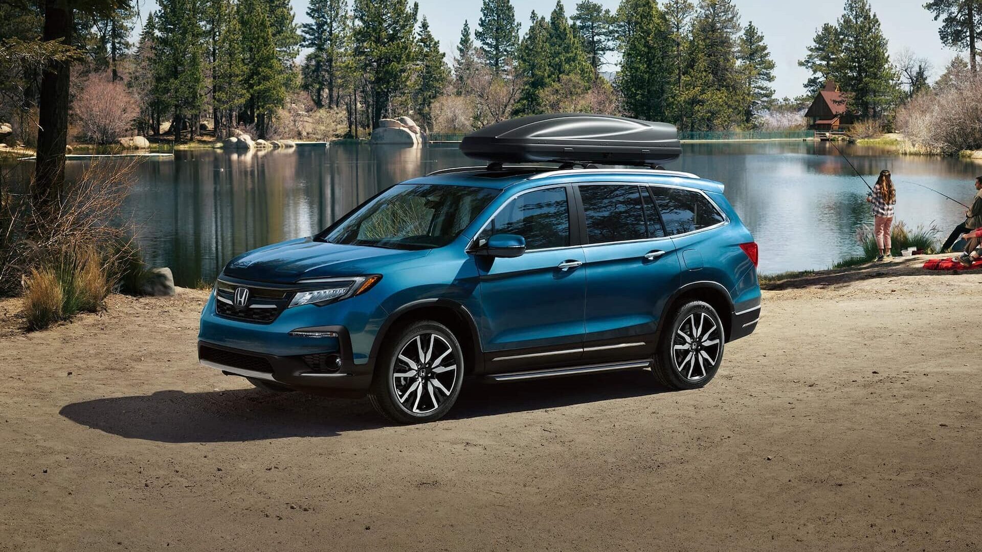 Family enjoying a camping trip with a Honda Pilot loaded with gear on top