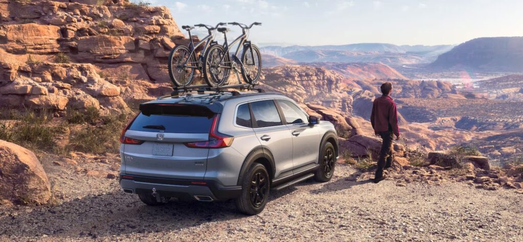 Honda CR-V parked in a scenic location with bikes loaded on top.